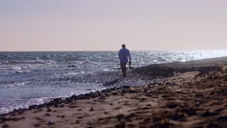 Man-walking-at-the-beach-in-slow-motion