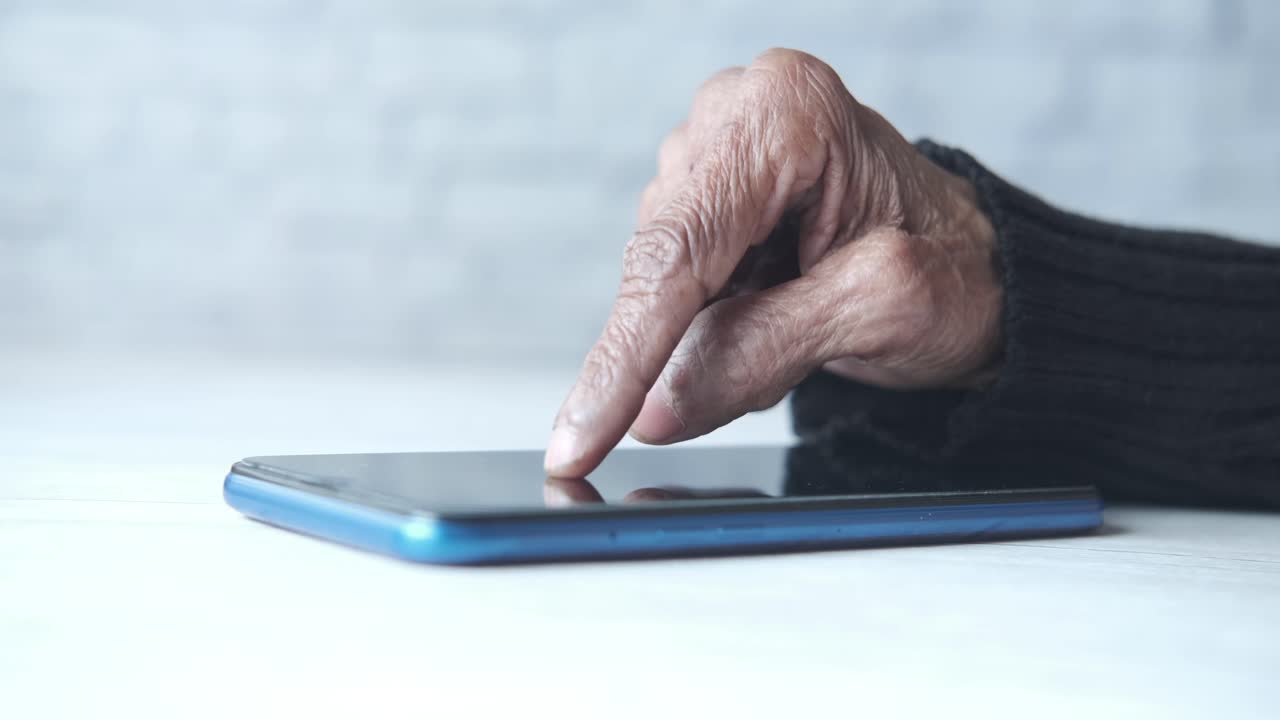 persona de edad avanzada que utiliza un teléfono inteligente