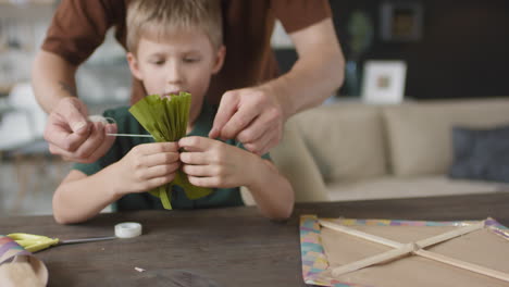 father and son making a kite together