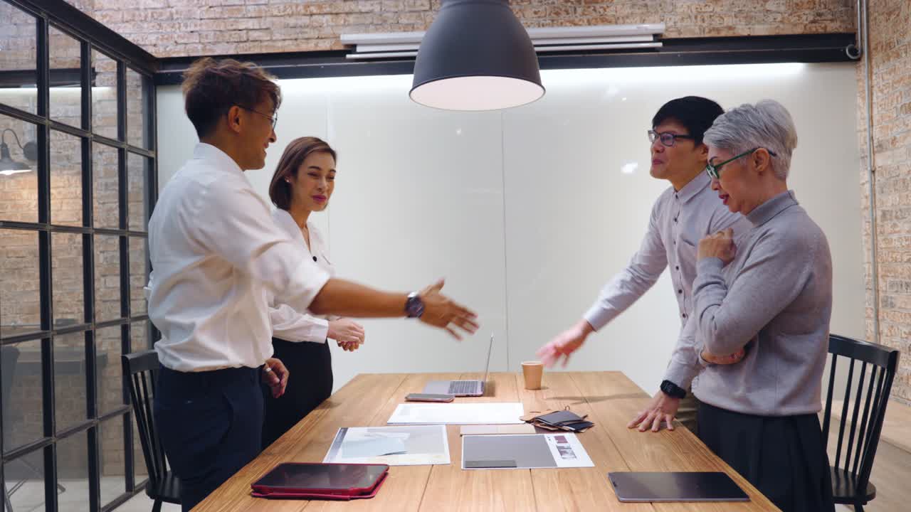 Group of business people shake hands after successful negotiations.