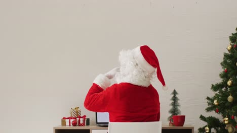 Video-of-santa-claus-using-laptop-with-copy-space-over-white-background