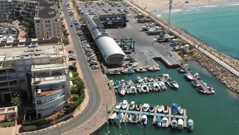 several ships are moored at a jetty while other ships are parked in the shed on the side on a summer day in herzeliya, israel