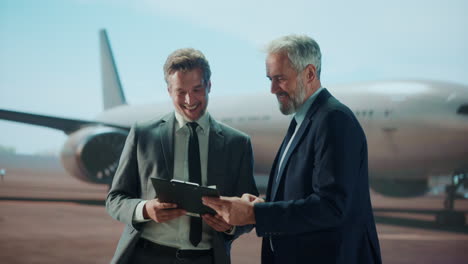 businessmen shaking hands at airport