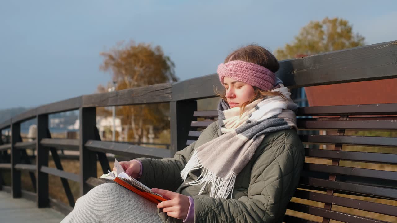 Kvinde, der læser en bog på en bænk
