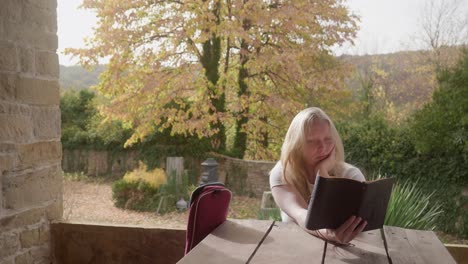 Blonde-girl-reading-distracted,-looks-to-camera-gestures,What