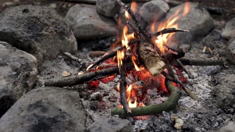 Pequeña-Fogata-Rodeada-De-Rocas-Ardiendo-Pacíficamente-Con-Llamas-Naranjas