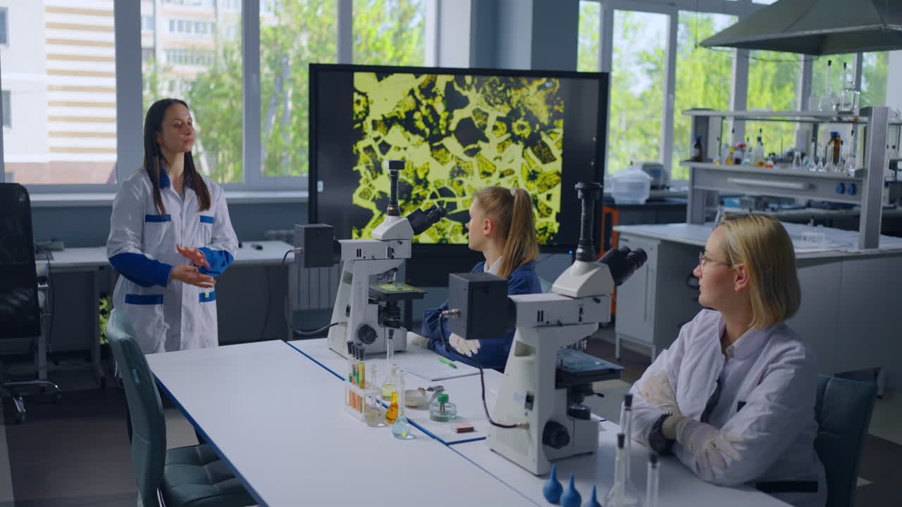 студенты наук наблюдают за микроскопическими образцами