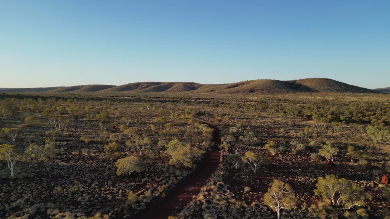 Ripresa aerea panoramica di una strada abbandonata nel deserto australiano al tramonto.