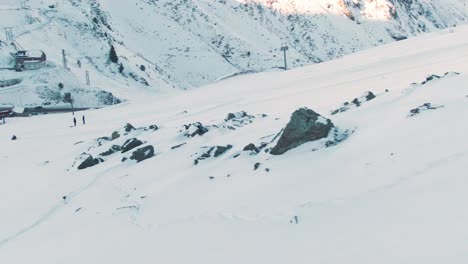 drone aerial view following a skier passing through rocks on a snow piste in the french alps europe