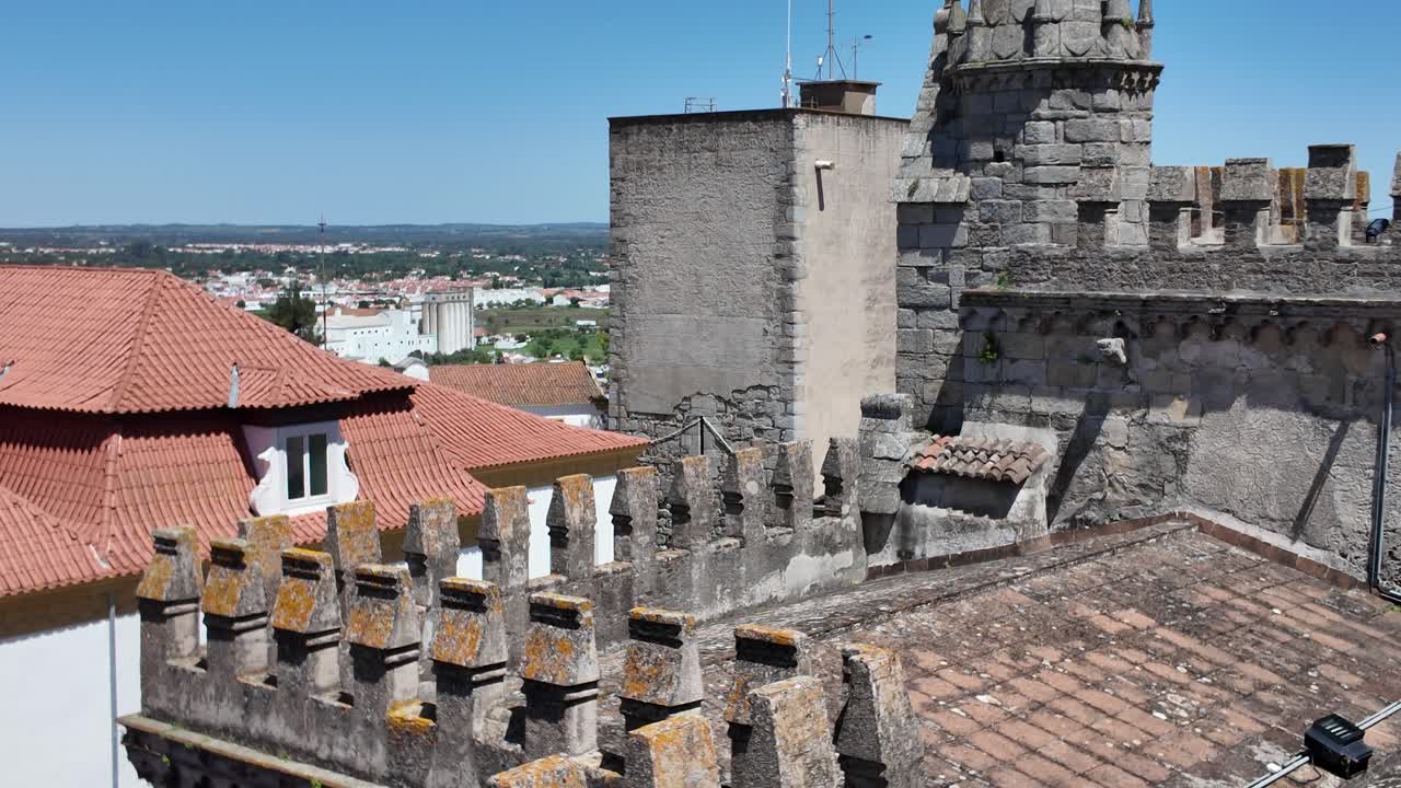 Architectural detail of the Cathedral of Evora with typical rooftops and the Alentejo landscape in the background