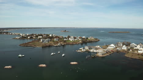 drone shot of fishing town on peninsula surrounded by sea water, maine