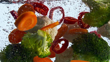 mix fresh vegetable falling in water super slow motion closeup. veggies floating