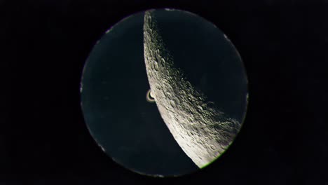 saturn being occulted by the moon as seen through a telescope eyepiece