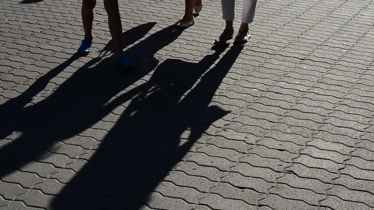 Luce e ombra, riflesso di persone nei raggi del sole al tramonto. Persone e le loro ombre