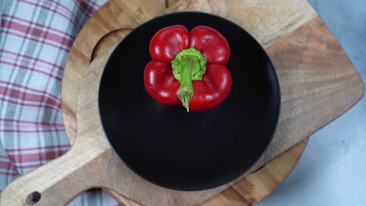 고무 장갑을 입은 여자의 손은 토마토, 고추, 호박을 테이블 위에 빈 접시에 놓습니다.