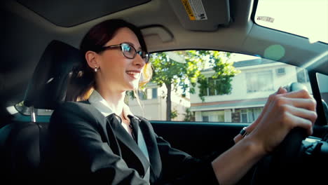 Business-woman-driving-while-smiling-and-laughing