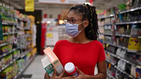 latin young woman wearing a face mask shopping in supermarket