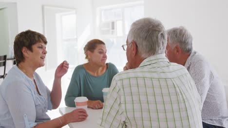 Amigos-Mayores,-Hombres-Y-Mujeres,-Sentados-En-Una-Mesa-Juntos-Socializando-Antes-De-Su-Baile-De-Salón.