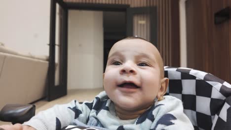 un momento conmovedor capturado cuando un bebé de 4 meses se sienta alegremente en un andador, irradiando sonrisas adorables, una escena deliciosa que muestra las primeras etapas del desarrollo y la felicidad de un bebé