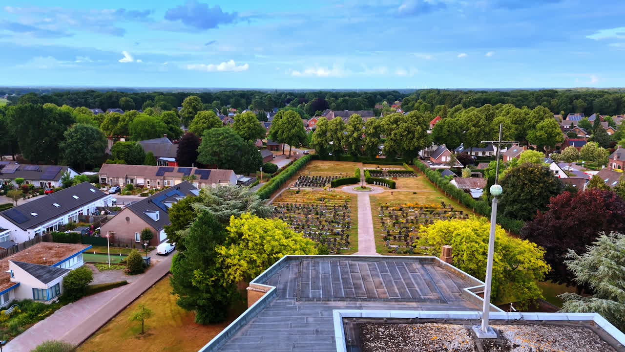 Approaching the H.Theobalduskerk Church in Overloon, Netherlands. Residential houses and cemetery around