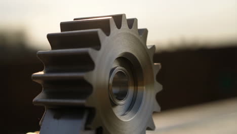 close-up of a metal gear or sprocket with warm bokeh background