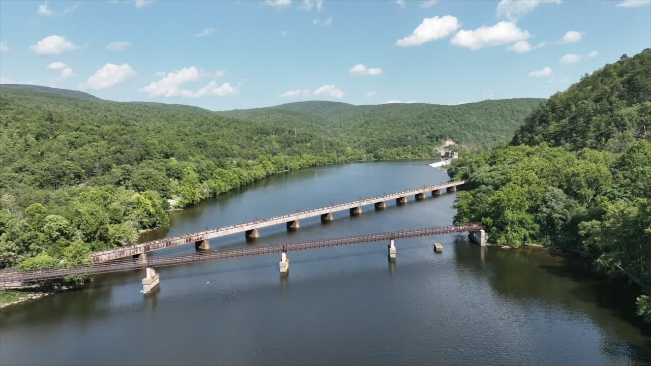 tomada aérea de un puente peatonal colgante sobre el río james en virginia rodeado de verdes montañas idílicas en verano