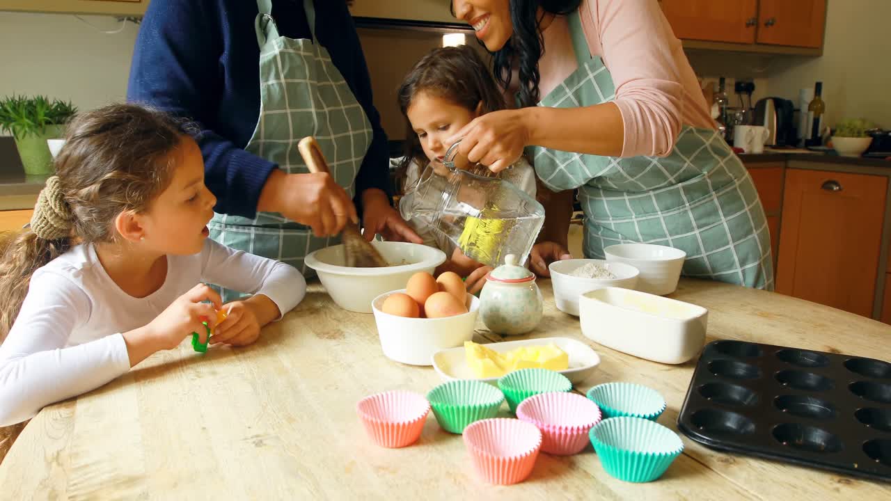 Siblings preparing food with family in kitchen 4k