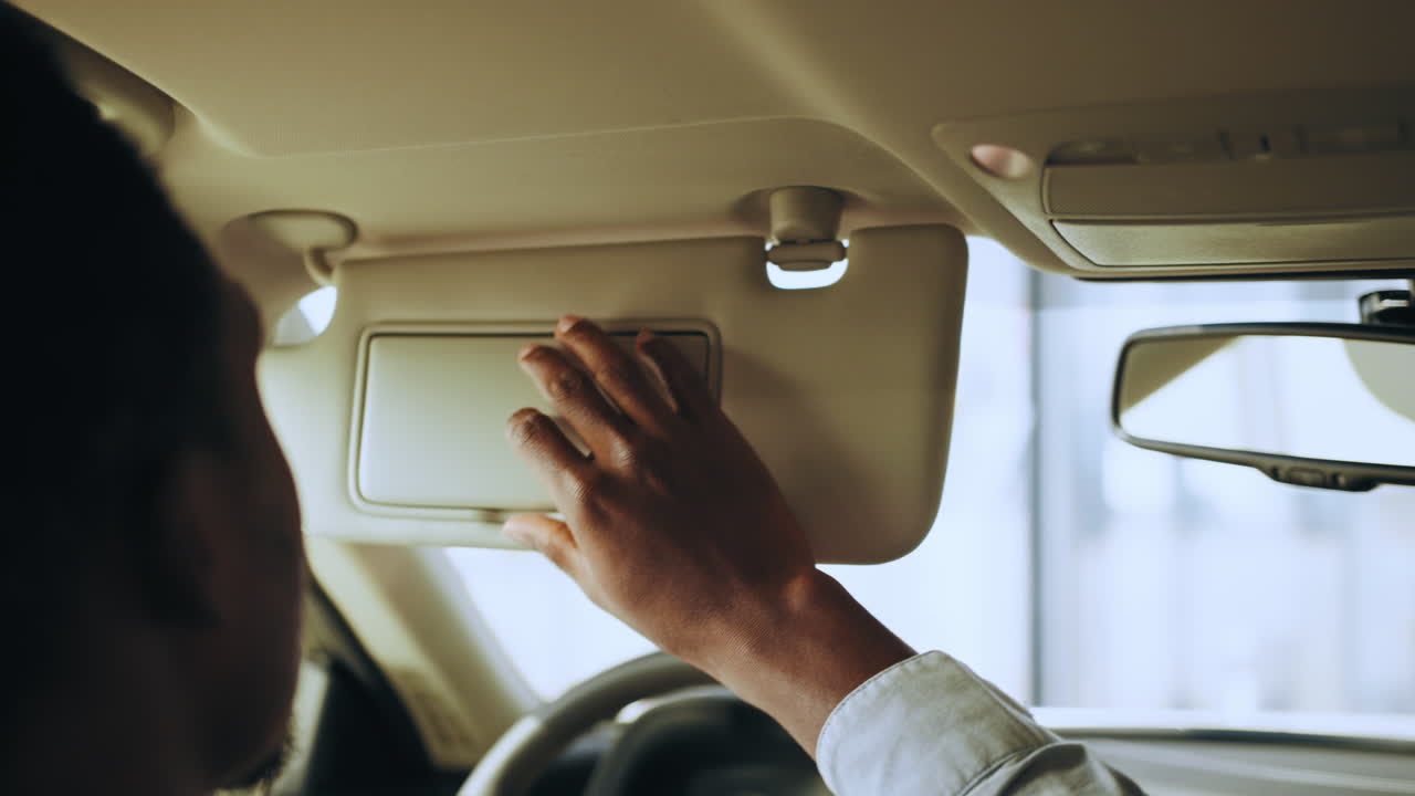 persona ajustando el visor solar en un coche