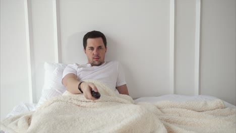 hombre viendo la televisión en la cama