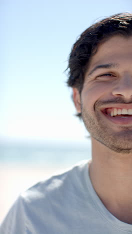 vertical video: smiling man enjoying sunny day at beach, close-up of face and teeth