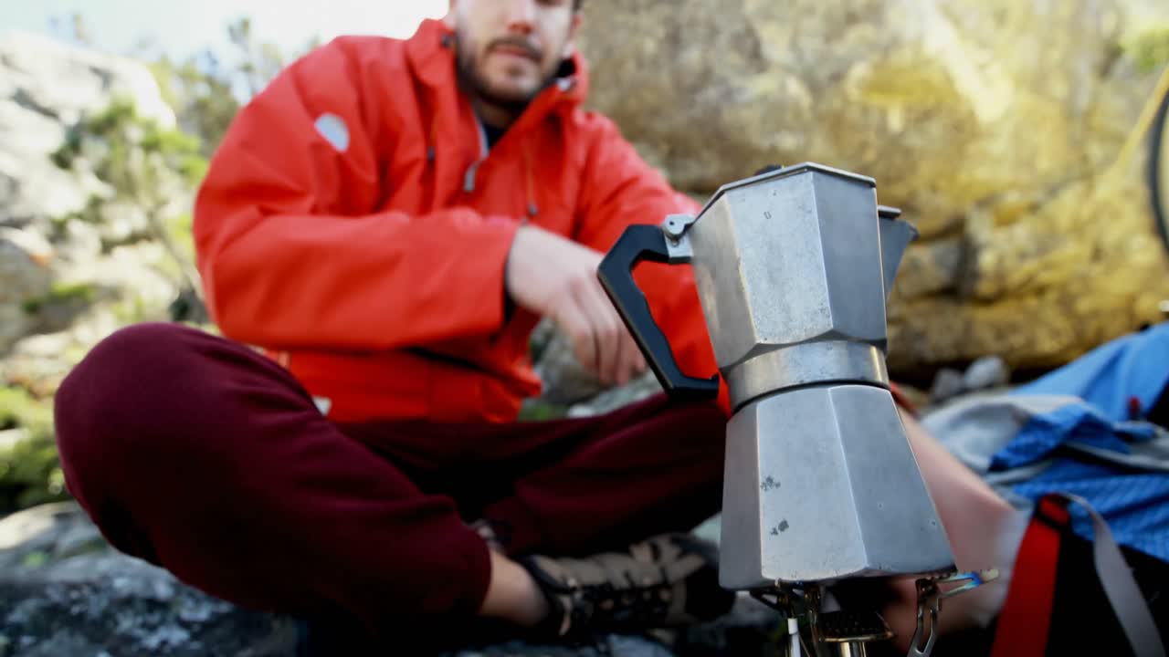 un escursionista maschio che prepara il caffè in campagna 4k
