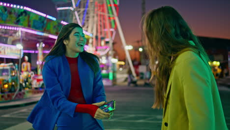 happy best friends embracing meeting at amusement park. smiling girls hugging