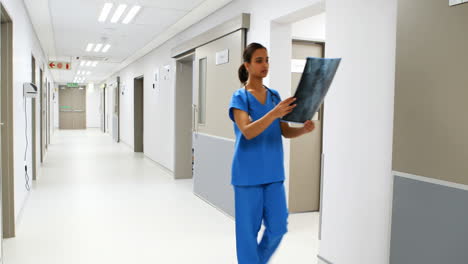 female doctor examining x-ray in corridor