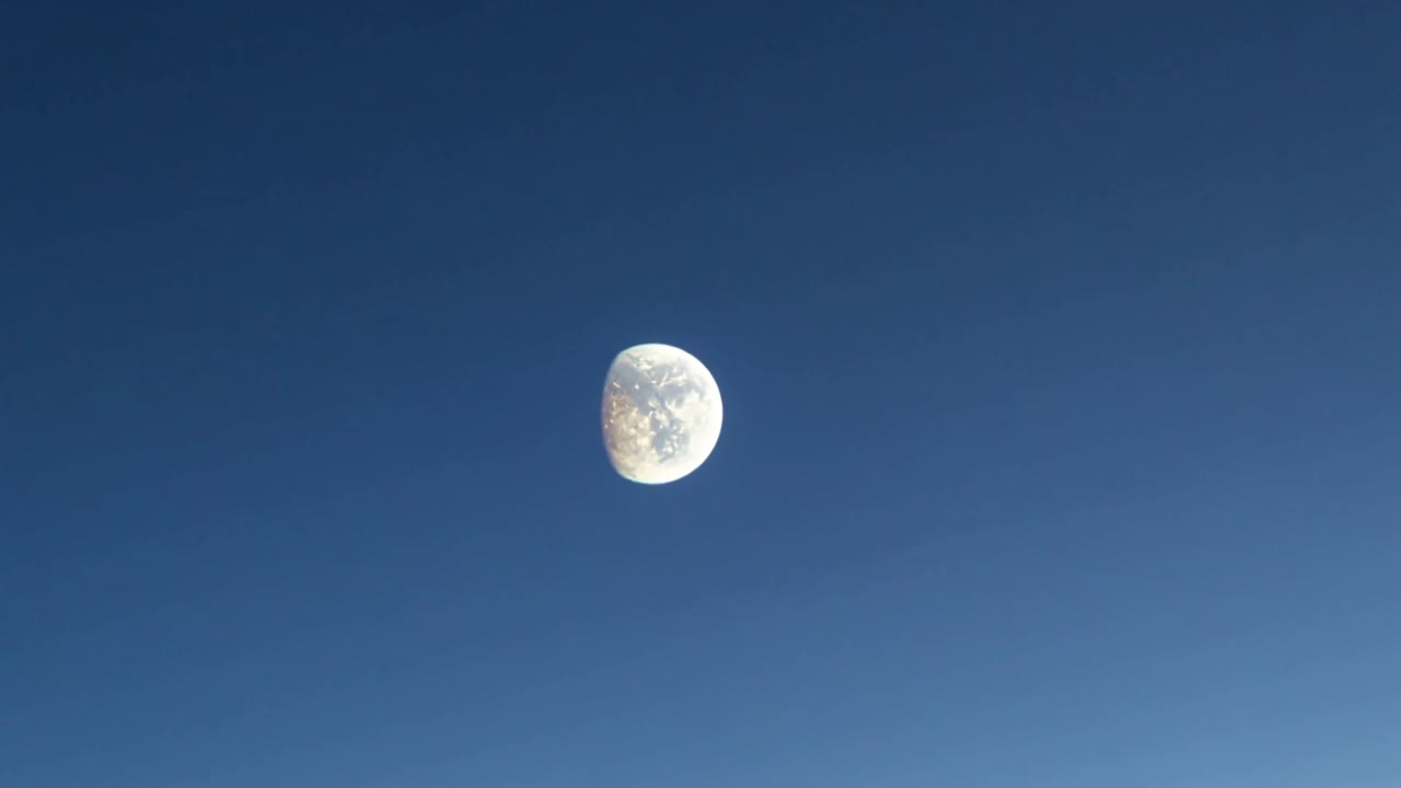 フレームが進行するにつれて、深い青空を右下へと滑るように移動し、三日月を見せる月