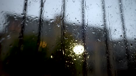 vista de cerca en el agua de lluvia corriendo por la ventana con riel de seguridad