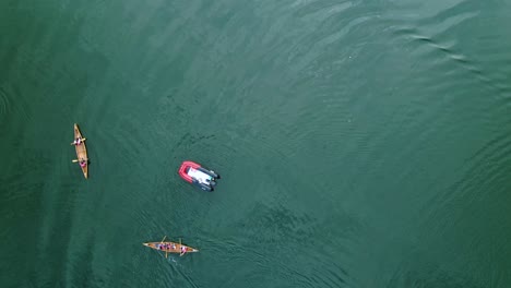 a red motorboat leading the canoe