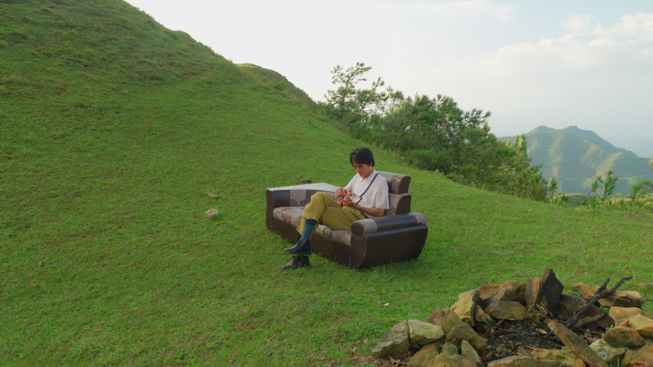 아시아 예술가 뮤지션은 빈티지 가죽 소파 소파에 앉아 기타 우쿨레를 연주합니다.
