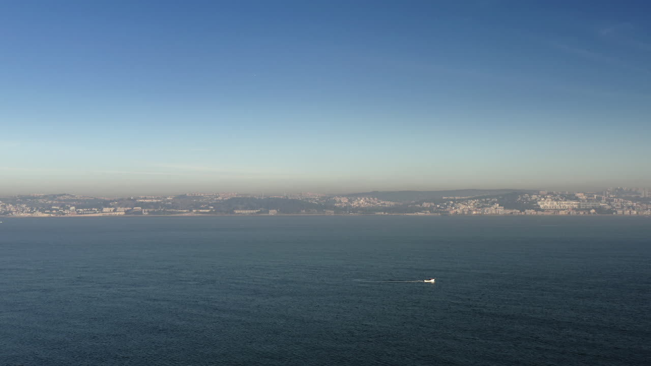 배경에 리스본이 있는 큰 강 테조에서 순항하는 흰 귀리