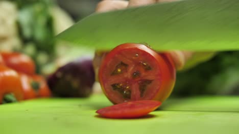 Close-up-on-Damascus-steel-blade-knife-cutting-red-tomato-into-slices