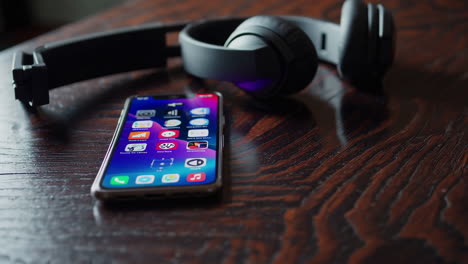 smartphone and headphones on a wooden table