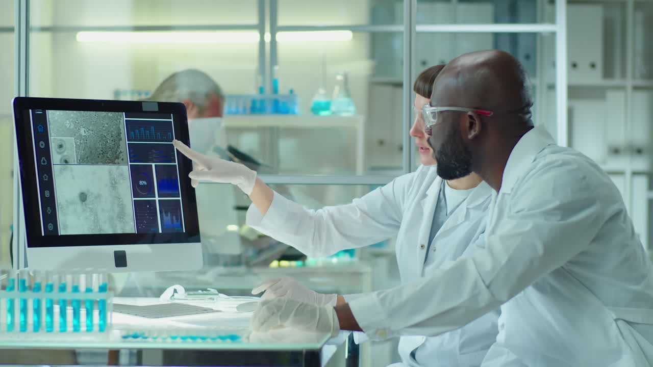 Diverse Scientists Discussing Micrograph on Computer