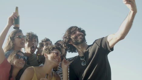 grupo de amigos felices tomando selfie durante una fiesta en la azotea