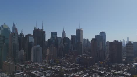 aerial drone view of a sunny and perfectly clear view of manhattan new york city, with the empire state building and the one trade center skyscraper on the background