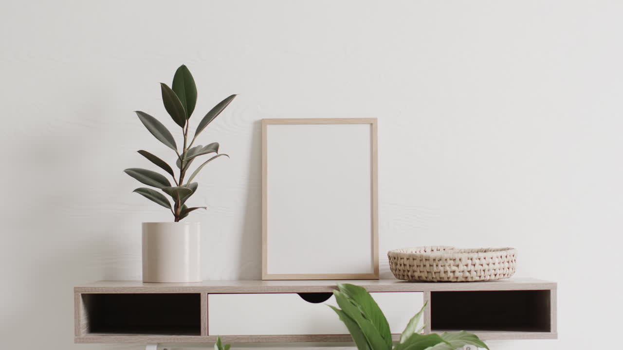 marco de madera con espacio de copia en fondo blanco con planta en el escritorio contra la pared blanca