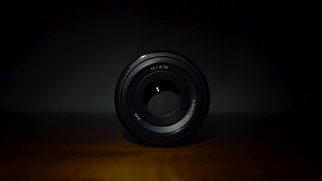 A cinematic 50mm lens on a wooden surface with soft lighting and a dark background