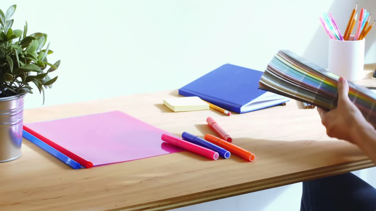 비즈니스 임원 이 책상 에서 색상 표본 을 선택 하고 있다