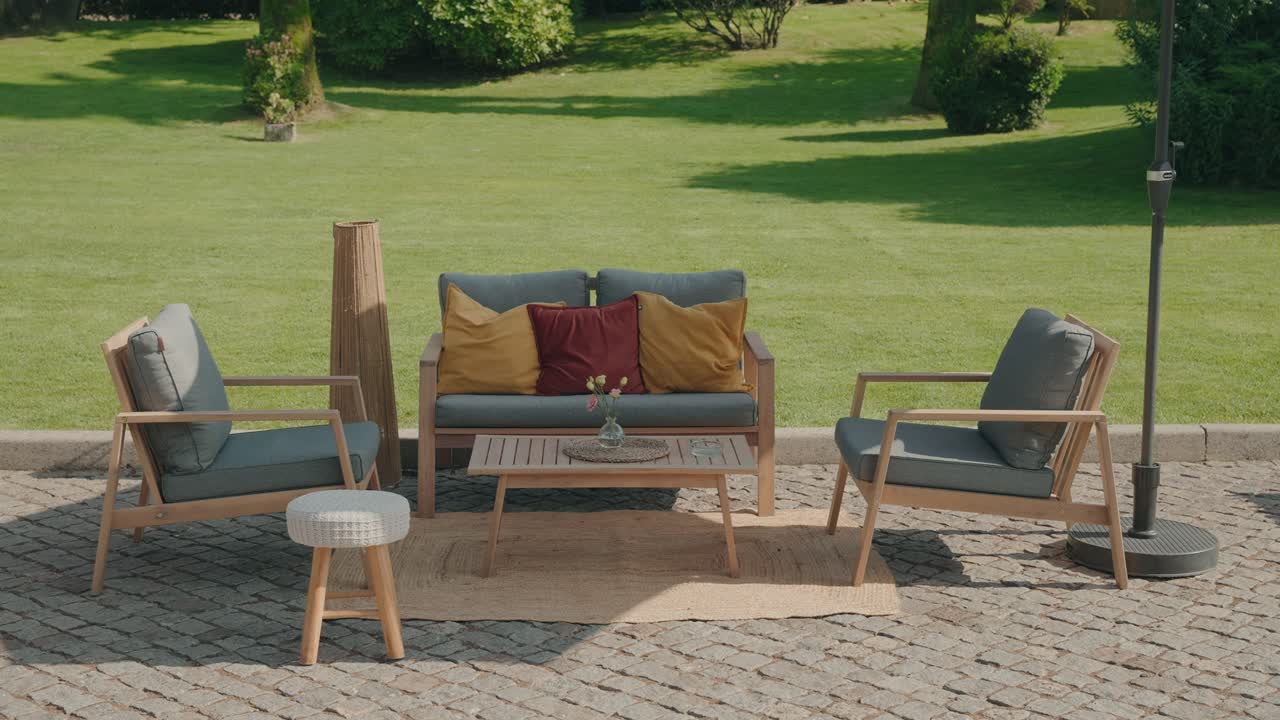 Cozy outdoor seating with wooden furniture arranged on cobblestone in warm sunlight
