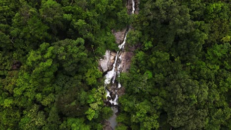 cámara aérea de drones volando a lo largo de una montaña, una cascada y una selva tropical en la región siempre verde de la isla de koh phangan en tailandia