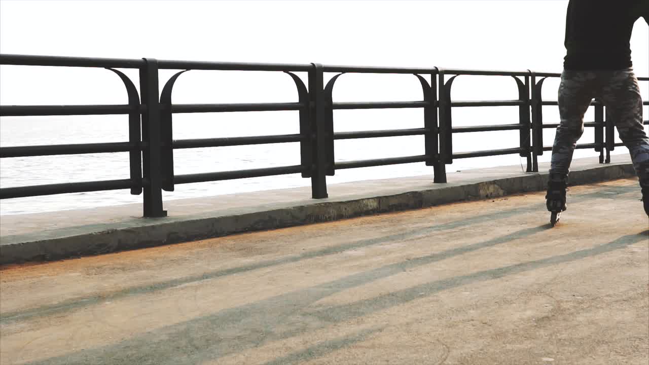 persona que hace patinaje en una pasarela costera