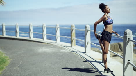 woman stretching and exercising by the ocean